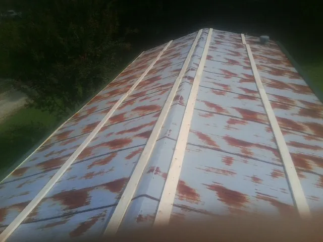 Rusted metal roof panels with new wood purlins before replacement — Storm Damage Roof Repair in Neffs by Roofing Brothers